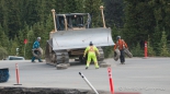 ... bei der Arbeit ... damit die Raupe über die Straße fahren kann, werden alte Reifen vor die Ketten geschmissen...