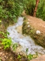 Der Bach mit warmen Wasser führt direkt entlang des kleinen Spazierweges vom Fluss zu den Becken und zurück