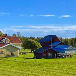die schwedischen Häuser liegen malerisch in grünen Wiesen